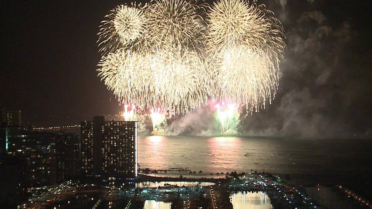 Wide shot of fireworks for New Years Eve over the water in Oahu, Hawaii, USA